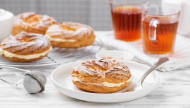 Ev yapımı choux pastası Paris Brest badem gevreği ve şeker tozu ile.