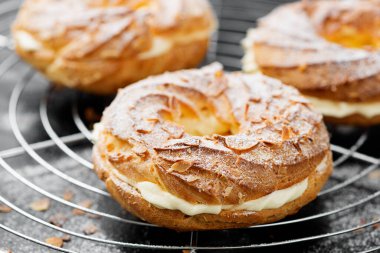 Ev yapımı choux pastası Paris Brest badem gevreği ve şeker tozu ile.