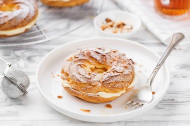 Ev yapımı choux pastası Paris Brest badem gevreği ve şeker tozu ile.