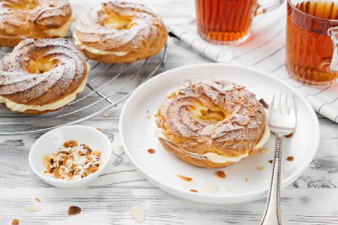Ev yapımı choux pastası Paris Brest badem gevreği ve şeker tozu ile.