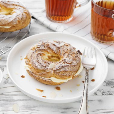 Ev yapımı choux pastası Paris Brest badem gevreği ve şeker tozu ile.