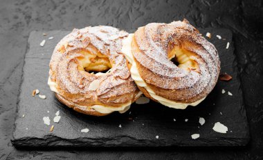 Ev yapımı choux pastası Paris Brest badem gevreği ve şeker tozu ile.