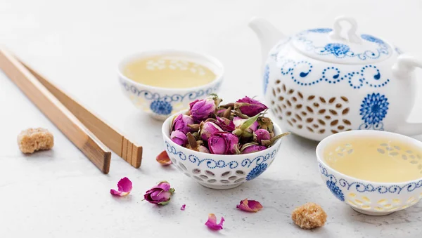 Herbal tea with roses on light gray background.