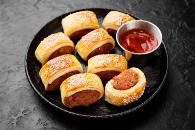 Lezzetli ev yapımı sosisli rulo domates sosuyla servis ediliyor..