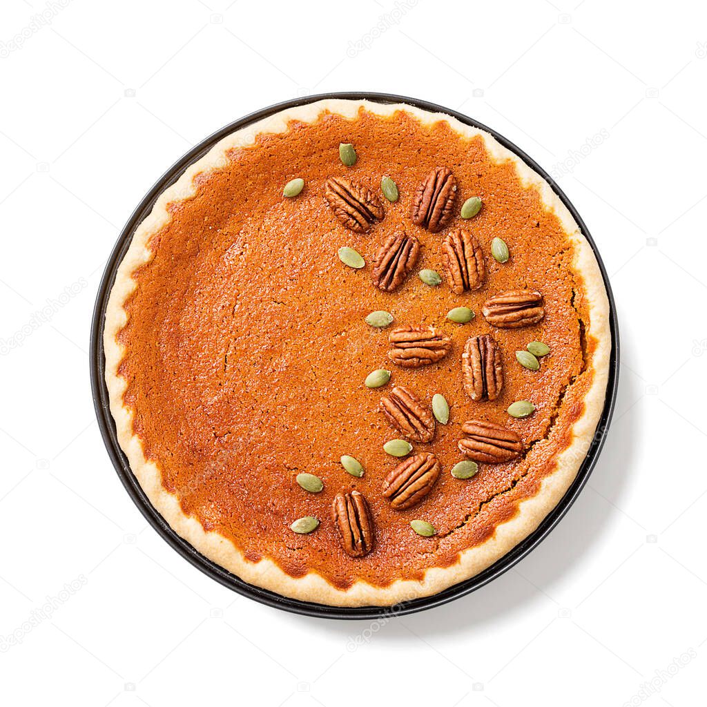 Festive Homemade Pumpkin Pie decorated with pecan nuts and pumpkin seeds. isolated on white background