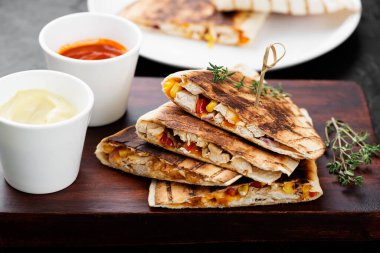 Meksika quesadilla 'sı, tavuk eti, tatlı mısır ve biber farklı soslarla servis edilir..
