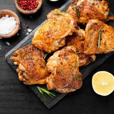 Grilled chicken thighs with spices and lemon. Top view clipart