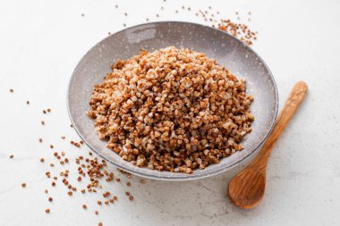 Açık gri arka planda tereyağlı lezzetli ve sağlıklı karabuğday lapası..