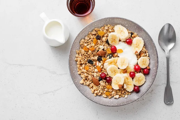 健康的な朝食 新鮮なグラノーラ 軽い灰色の背景にヨーグルトバナナとクランベリーとムズリー トップビュー — ストック写真