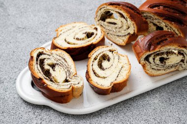 Sliced Poppy roll cake on a serving board.	