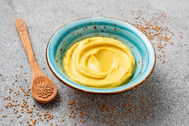 Delicious organic mustard sauce in bowl with wooden spoon.		