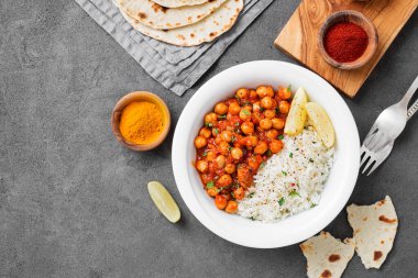Traditional Indian dish chickpea chana masala with rice and flatbread.	
