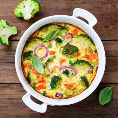 Frittata or casserole with broccoli and vegetables in baking dish. Vegetarian recipe.	