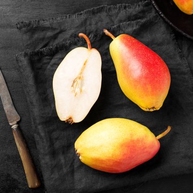 Siyah ahşap bir masada taze taze organik armutlar.