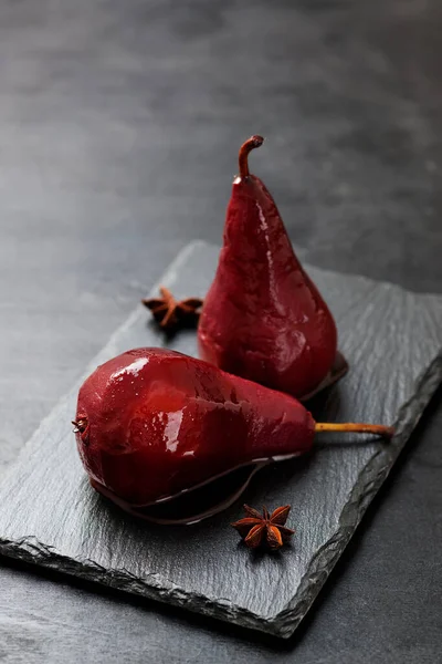 stock image Plate of pears poached in red wine, dessert decorated with chocolate sauce .	