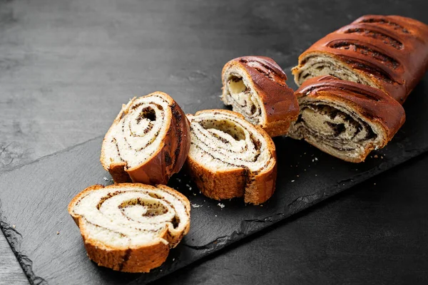 Sliced Poppy roll cake on a serving board.	