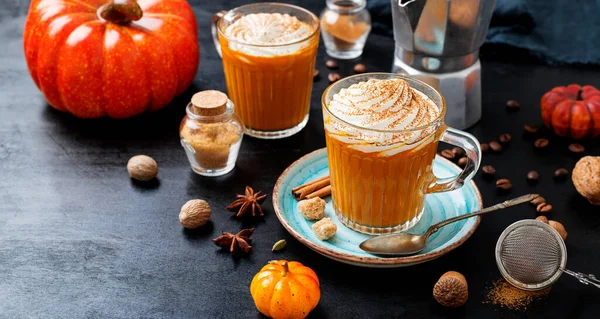 Pumpkin spice latte in a glass mug with cinnamon and nutmeg .