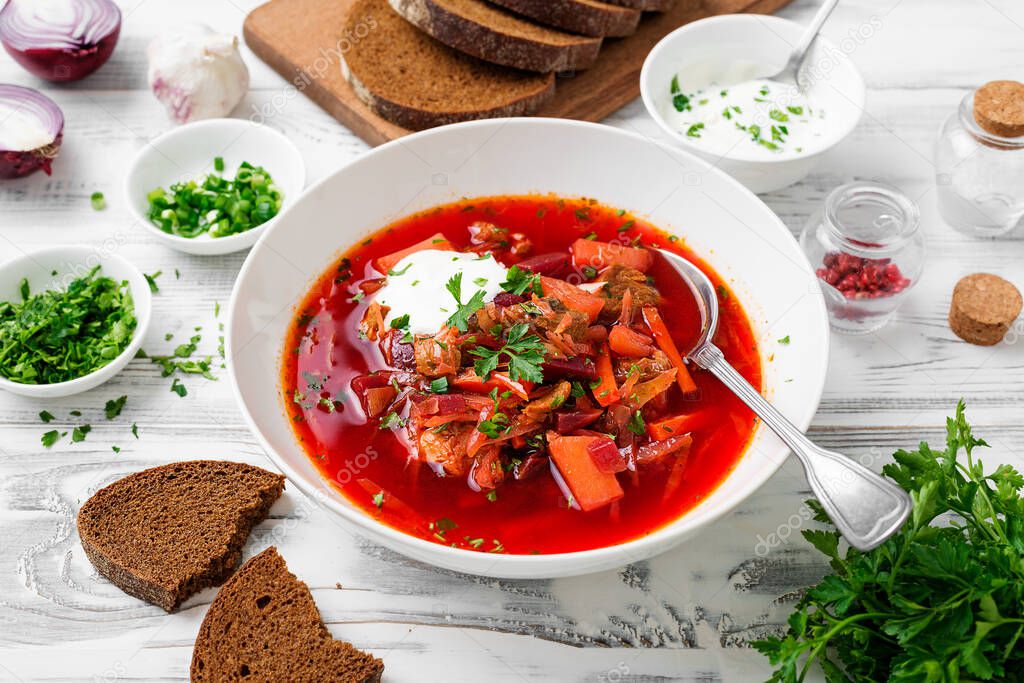 Beetroot soup - Traditional Ukrainian or Russian borscht with sour cream in a white bowl.