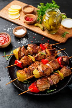 Kebabs - grilled meat skewers, shish kebab with vegetables on black wooden background. clipart