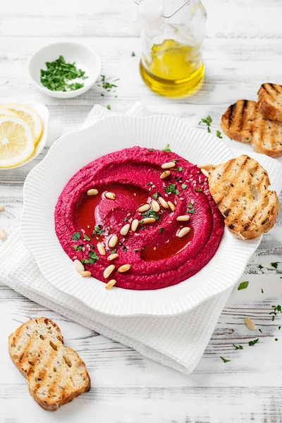 Gebakken Biet Hummus Met Geroosterd Brood Een Witte Keramische Plaat — Stockfoto