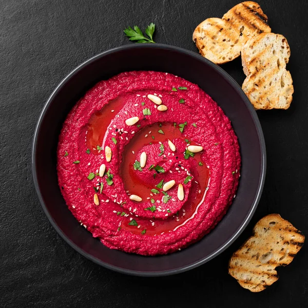 Baked Beet Hummus Met Geroosterd Brood Een Zwarte Keramische Kom — Stockfoto