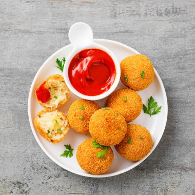 Ev yapımı Risotto Arancini peynirle doldurulmuş, domates sosuyla servis edilmiş..