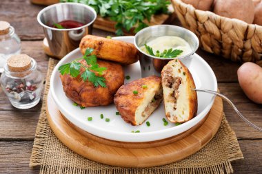 Patates köfteleri kıyma ile doldurulmuş, ekşi krema ve domates sosuyla servis edilmiş..