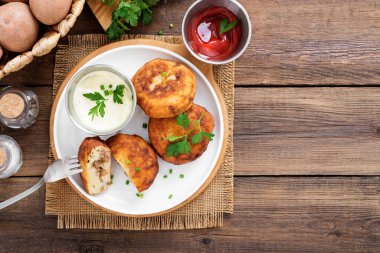 Patates köfteleri kıyma ile doldurulmuş, ekşi krema ve domates sosuyla servis edilmiş..