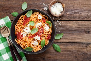 Domates soslu spagetti, parmesan peyniri ve fesleğenle süslenmiş mozzarella peyniri..