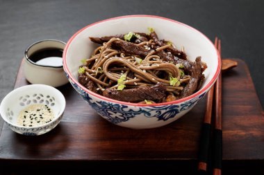 Erişteyle kızartma ve susam tohumuyla süslenmiş biftek. Soba eriştesi, Asya mutfağı..