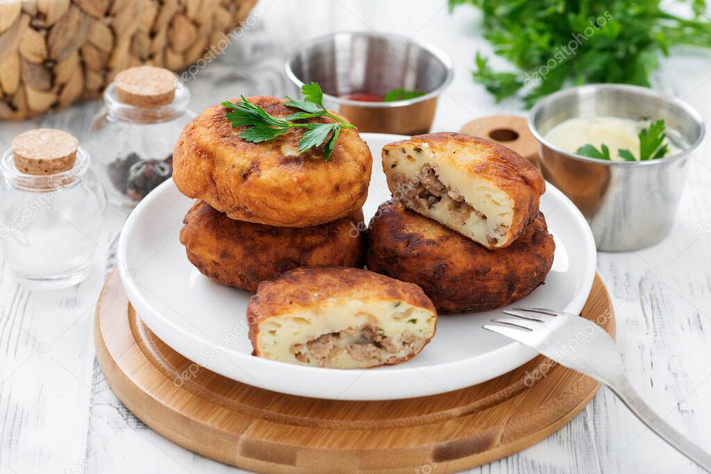 Potato patties (zrazy) Stuffed with minced meat, served with sour cream and tomato sauce.