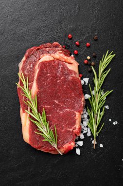 Çiğ et, siyah arka planda baharatlı biftek, üst manzara..