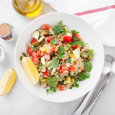 Taze domatesli kinoa tabbouleh salatası, salatalık ve taze yeşillikler..