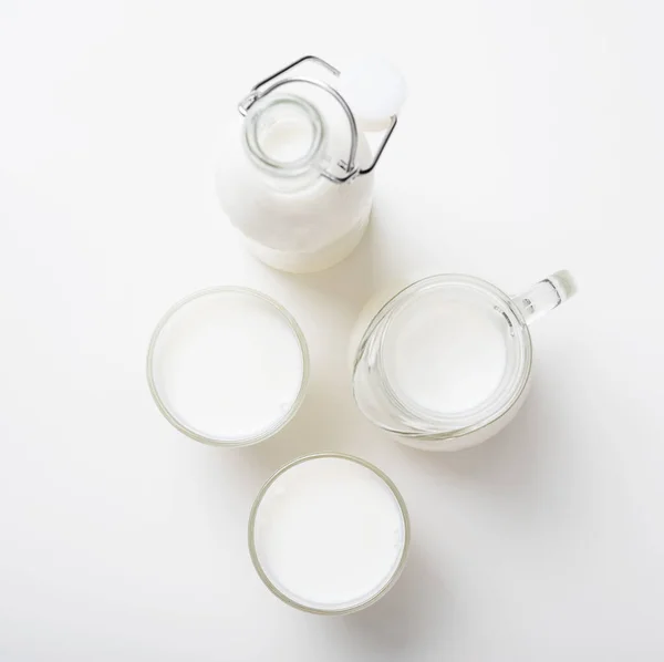 Μπουκάλι Κανάτα Και Ποτήρια Φρέσκο Γάλα Λευκό Φόντο Πάνω Όψη — Φωτογραφία Αρχείου