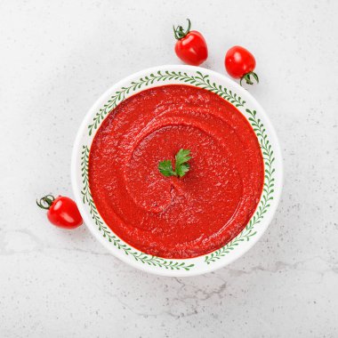 Açık gri taşlı arka planda domates çorbası. Üst görünüm.