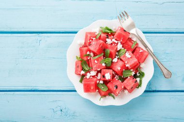 Yaz salatası, karpuz, peynir ve nane yaprağı. mavi ahşap arka planda