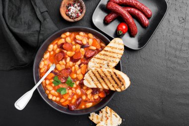 Tütsülenmiş sosis ve domates sosuyla haşlanmış beyaz fasulye. Fasulye çorbası..