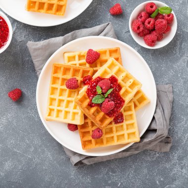 Gri arka planda taze ahududu ve reçelli geleneksel Belçika waffleları.