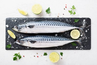 Taze balık. Siyah taş zemin üzerinde tuz, limon ve baharatlı uskumru..