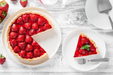 Beyaz ahşap arka planda lezzetli çilekli tart.