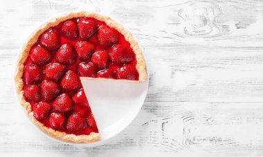 Beyaz ahşap arka planda lezzetli çilekli tart.