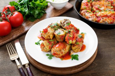 Geleneksel doldurulmuş lahana ruloları kıyma ve pilav, domates sosunda servis edilir..