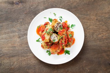 Geleneksel doldurulmuş lahana ruloları kıyma ve pilav, domates sosunda servis edilir..