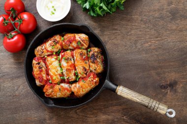 Geleneksel doldurulmuş lahana ruloları kıyma ve pilav, domates sosunda servis edilir..