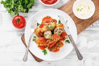 Geleneksel doldurulmuş lahana ruloları kıyma ve pilav, domates sosunda servis edilir..