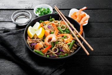 Kızarmış erişteyi karides ve sebzeyle karıştır..