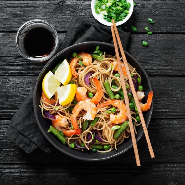 Kızarmış erişteyi karides ve sebzeyle karıştır..