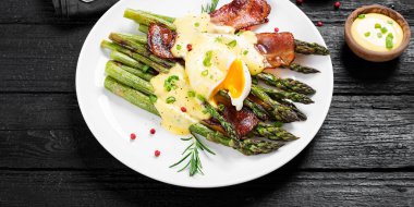 Izgara kuşkonmaz haşlanmış yumurta, pastırma ve Hollandaise sosuyla servis edilir..