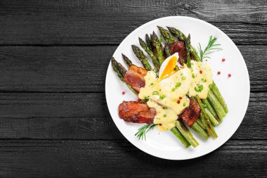 Izgara kuşkonmaz haşlanmış yumurta, pastırma ve Hollandaise sosuyla servis edilir..