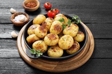 Kızarmış patates, siyah ahşap arka planda kızartma tavasında..